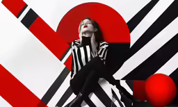 a woman with a cellphone sitting on a striped background
