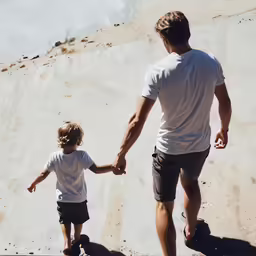 man and little boy are walking on the skateboard ramp