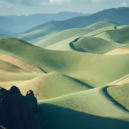 the rolling hills in the distance cover a vast amount of grass