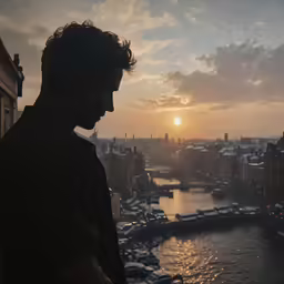 a person looking down at a lake in front of a city