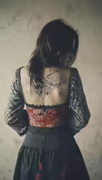 a woman with tattoo on her back, wearing a dress