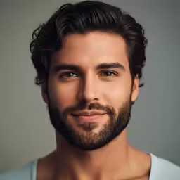 a bearded man wearing a blue shirt with short hair