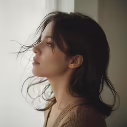 a woman is standing in front of a window