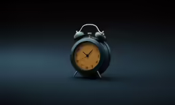a black and orange alarm clock on a black table