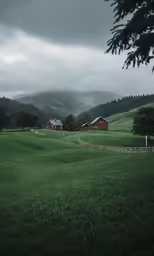 an image of houses on a mountain slope with foggy skies