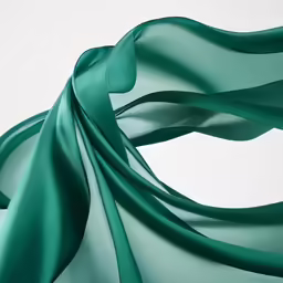 an image of green silk material waving in the wind
