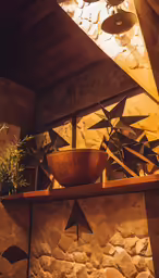 there is a bowl sitting on the shelf next to a potted plant