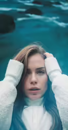 a woman in white sweater with hands on her head
