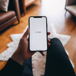 a person sits on the floor with their phone in their hand