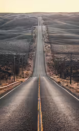a long straight road running through a dry landscape