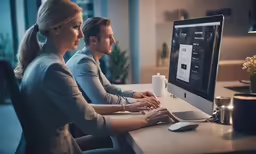a man and woman working on the computer