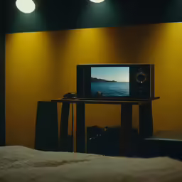 a television is sitting on a small table in front of a big screen