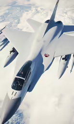 a jet flying through the sky above clouds
