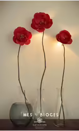 three vases that have flowers in them