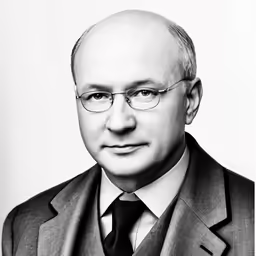 a man wearing glasses and a suit with a tie