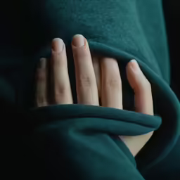 a person wrapped up in a dark green coat