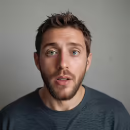the man is wearing a gray shirt with the camera