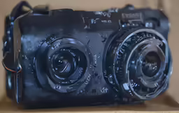 a black camera is sitting on a wooden shelf