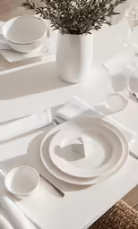 the table is set for one person with a small flower arrangement
