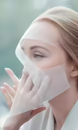 a woman covering her face with clear mesh