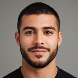 a man with a mustache posing for a headshot