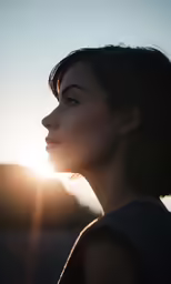 a woman with black hair and eyeshade standing in the sunset