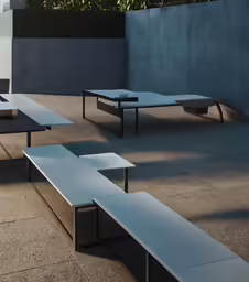 many black and silver benches outside in the shade