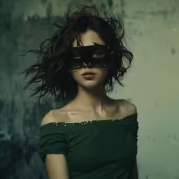 a woman with large glasses has her hair flying