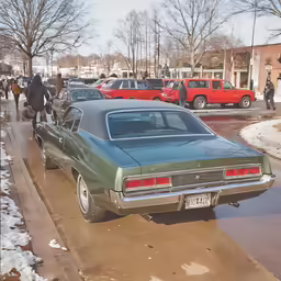 a green vintage car parked along the curb