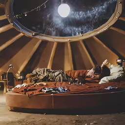 a man sleeping on top of a round bed