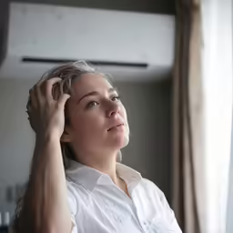a young woman looking out a window in an apartment
