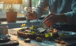 someone sprinkling seeds on some plant life