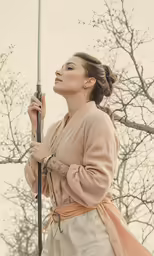 a woman holding an umbrella next to trees