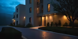 a long driveway with two white building behind it at night