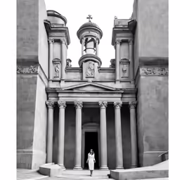 black and white photograph of a woman entering an ancient building