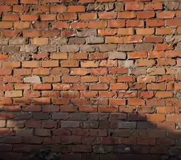 a man leaning on the side of a building