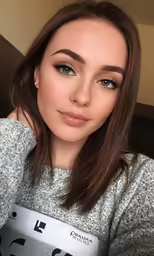 a girl with light brown eyes and an arabic - styled top