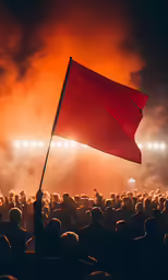 a man holds a red flag in front of an audience