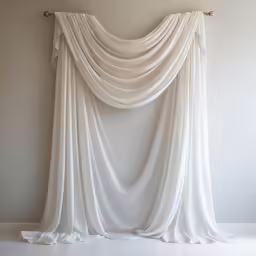 a drapeed curtain is mounted up against the wall