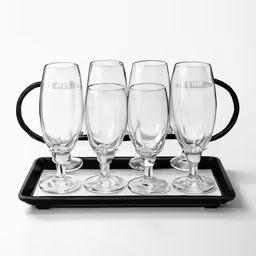 four wine glasses sit in front of a black tray