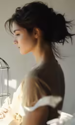 a woman in a white dress is holding a birdcage