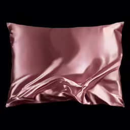 a pink satin pillow is on the table