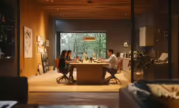 a couple sits at a dinner table and works on the computer