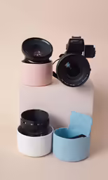 some cameras are sitting on a white box