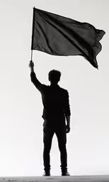 a man standing with his hands raised up holding a black flag