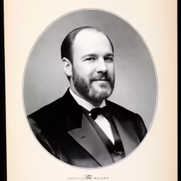 a portrait of a man in tuxedo smiling for the camera