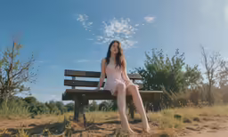 a woman sitting on top of a wooden bench
