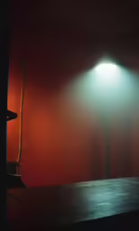 a wood table and lamp on red wall