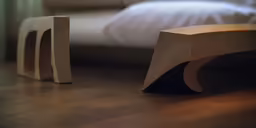 wooden furniture on the floor and a bed in the background