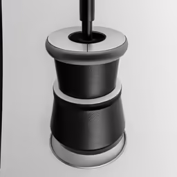 a toilet brush next to a black and white bathroom